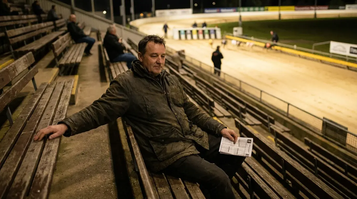 Punter calmly watching a greyhound race from the stands with a relaxed posture at an evening meeting