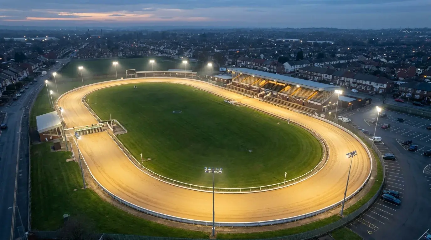 UK greyhound tracks — aerial view of a British greyhound stadium with an oval sand track and floodlights